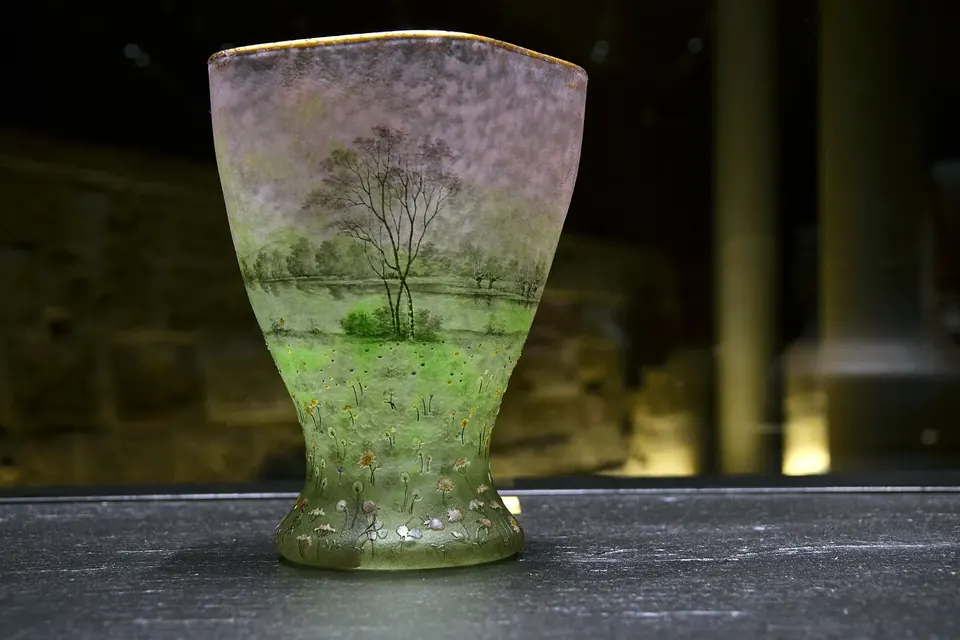Vase Daum de la fin du XIXe siècle en verre teinté, décoré de motifs végétaux et de fleurs de prairie, présenté au musée des Beaux-Arts de Nancy
