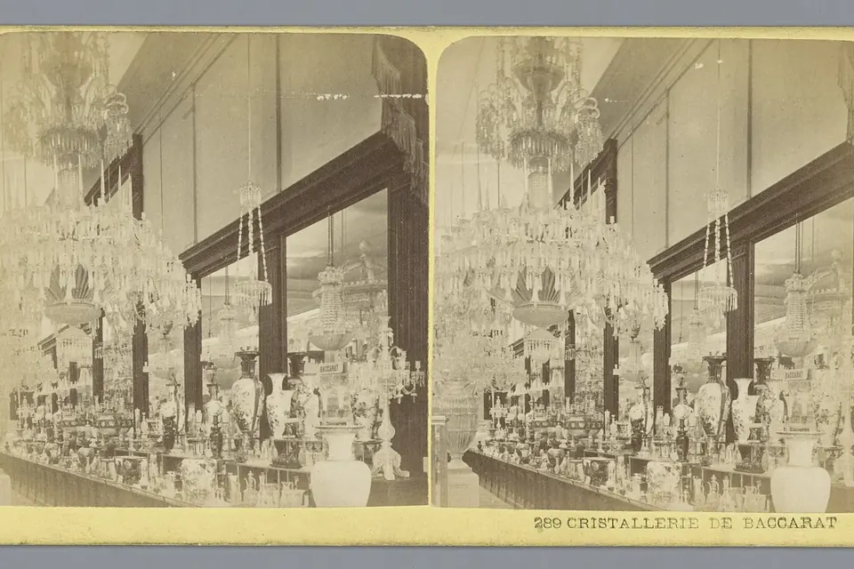 Photographie ancienne d'une vitrine de l'Exposition universelle de 1878 remplie de pièces de cristal de Baccarat : vases, coupes, carafes et grands objets taillés