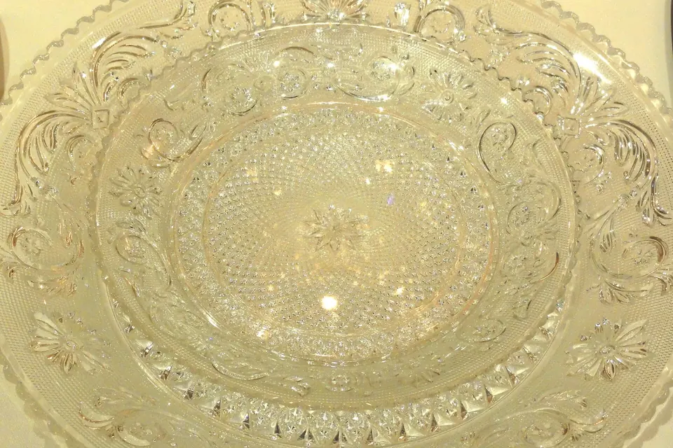 Gros plan sur un plat en cristal taillé exposé au musée de la cristallerie de Baccarat, dont les facettes et motifs rayonnants accrochent la lumière